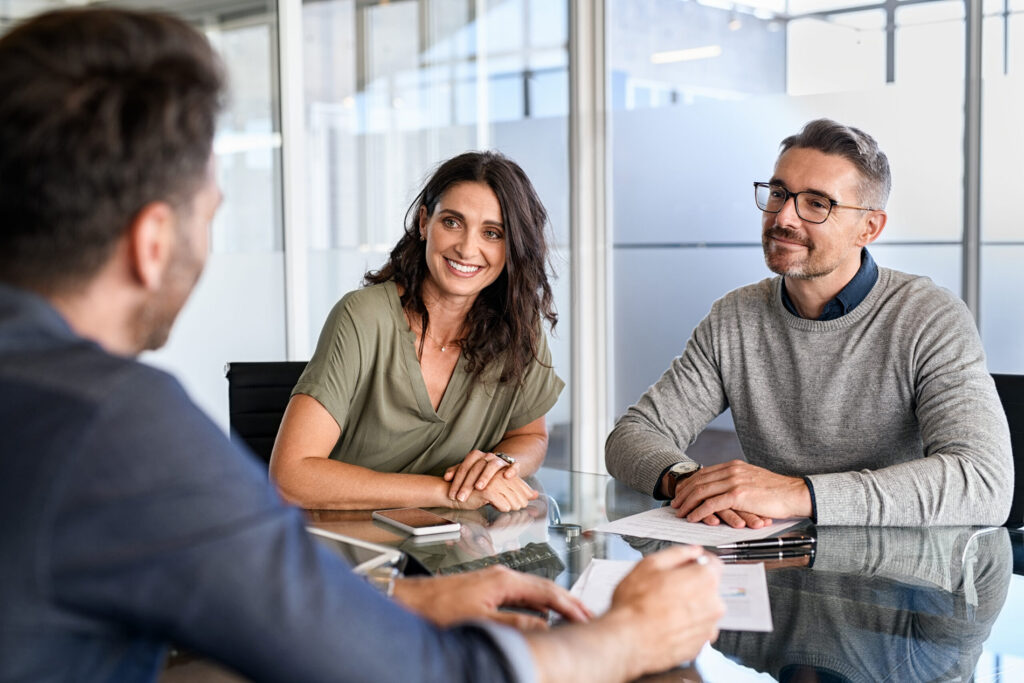 Smiling mature couple meeting with an IT consultant.